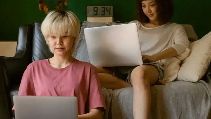 Two women looking at a laptop, researching whether Umingle is safe